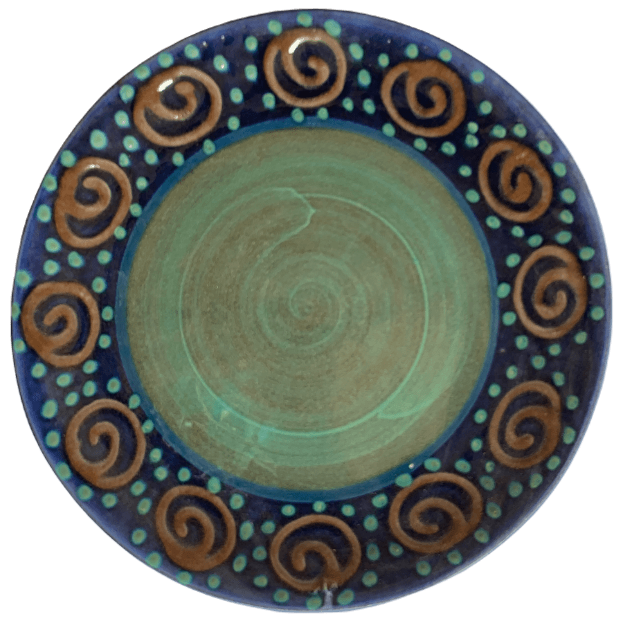 Ceramic pottery design with blue background reddish brown squirls.